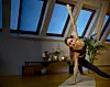 Katrine Bonde laver yoga på en måtte, og strækker armen over hovedet og balancerer med den anden.