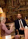 Dronningen fik sig en drink og en snak med Mikkel Hammer Elming, der var iklædt et sort jakkesæt med et mønstret slips i en skøn stue.