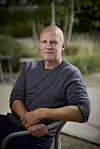 Troels Lyby sidder på en stol med en baggrund af natur