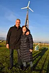 Gert og Tina foran vindmøllen, der producerer strøm, når det blæser – det vil sige, det meste af tiden.