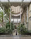 Indendørs botanisk have med høje palmer under stort glastag. Glyptoteket.