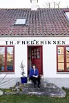 Huset blev i sin tid bygget til Theodor Frederiksen, der både boede i huset og havde købmandsbutik. Her hvor Ditte sidder var der indgang til butikken, og hun har et fotografi af Theodor og hans medarbejdere, der også blev fotograferet her.