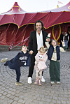 Dennis Knudsen står med tre børn foran et stort rødt cirkustelt ved Cirkus Arena.