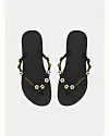 Sorte Havaianas flip-flops med små hvide blomster på remmene set oppefra.