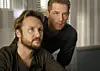 To mænd ser fokuseret på en skærm i et lyst kontor