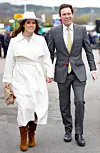 Princess Eugenie og Jack Brooksbank går smilende hånd i hånd ved Cheltenham Racecourse.