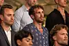 Flere mænd står på rækker ved en indendørs formel begivenhed.