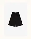 Sorte, løse bermudashorts med elastisk talje lagt fladt mod lys baggrund.