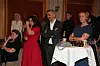 Forsamling af voksne ved et Strax‑arrangement står og lytter i en mødesal.
