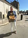 Mand står på slotsplads ved Amalienborg og holder en flettet kurv med nye kartofler.