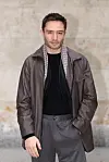 Ed Westwick står udendørs i brun jakke før Giorgio Armani-show i Milano.