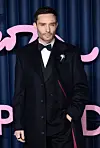 Ed Westwick i mørkt jakkesæt og frakke på den røde løber ved The Fashion Awards 2025.