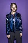 Søren Torpegaard Lund står foran lilla baggrund i blank mørkeblå jakke ved Dansk Melodi Grand Prix 2026