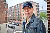 Palle Richard Laursen på altan i denimjakke med byens murstensbygninger bag sig.