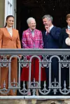 Den danske kongefamilie står smilende på Amalienborgs balkon under en fødselsdagsfejring.