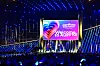 Oplyst Eurovision 2026-scene i Wiener Stadthalle med stor velkomstskærm og publikum i forgrunden.