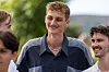 Unge mænd smiler og taler sammen i en udendørs setting