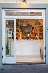 Facade af Gelateria della Passera med to ansatte bag den oplyste isdisk.