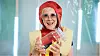Person i hotdog-kostume holder et stort glas og smiler til kameraet.