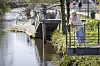 Jena Krogslykke læner sig mod et rækværk ved en åpromenade omgivet af forårsgrønt.