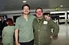 To mænd står og smiler i en lufthavnsterminal, fotograferet af Janus Nielsen.