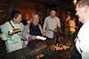 Folk får serveret grillede pølser af en kok ved et Strax-arrangement