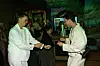 To personer i hvide outfits danser foran en bar ved et arrangement.