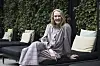 Ditte Hansen sidder på en mørk loungesofa foran en grøn væg med efeu under en pressedag.