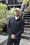 Person ved pressedag til 'De bedste år' står i en gård foran en trætrappe.