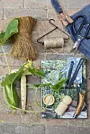 Udstyret skal være i orden, her er det et forklæde fra Malmø Gardenshow, mens pottepresse, garnholder og løgsætter er fra Søstrene Grene. Bogen om Drivhuset er fra Politikens Forlag og saksen er fra Plint