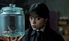 Wednesday (Jenna Ortega) holder glasbeholder med insekt i mørkt rum