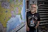 Flemming fra Hotel Romantik står foran et USA-vejkort ved siden af reol med souvenirs.