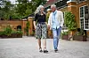 Gina Bakke og Erik Vilen går hånd i hånd foran en gul murstensbygning i Frederiksberg Have