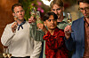 Flere personer holder champagneglas løftet under en aftenreception indendørs.