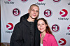 To gæster poser foran fotovæg med TV3- og Viaplay-logoer ved premierearrangement.