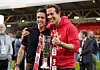 To personer på fodboldbane holder en Sky Bet-pokal og smiler til kameraet.