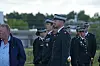 Danske officerer i paradeuniform står udendørs under en ceremoni