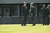 Strax-officerer i grøn uniform samtaler på græsplæne foran kaserne