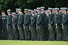 Uniformerede officerer står på række til udendørs ceremoni