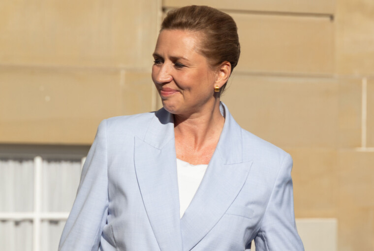 Mette Frederiksen i lyseblå blazer foran Amalienborgs lys sandfarvede facade.