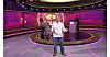 Phillip står foran to Jasmin og Oliver ved pulte i et lilla oplyst tv-quizstudie