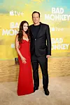 Kyla Vaughn og Vince Vaughn står foran en gul 'Bad Monkey' og Apple TV+ fotovæg.
