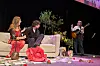 Sceneshow fra Bachelorette 2026-finalen med par på sofa og guitarist på scenen