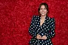 Kvinde smilende foran rød væg af roser ved Bachelorette 2026-finale
