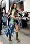 Dua Lipa går smilende forbi fans uden for Selfridges i London.