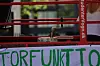Rød studentervogn med ølhane, papkasse og håndskrevet grønt banner set tæt på.