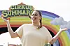 Sælma smiler med åbne arme foran farverig Cirkus Summarum-indgang med regnbue