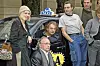 Gruppe af mennesker står ved en sort taxa med TAXI-skilt på taget.