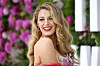 Blake Lively smiler på rød løber foran en blomsterbaggrund i London