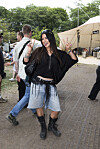 Smilende festivalgæst laver fredstegn på stien ved Roskilde Festival 2026.